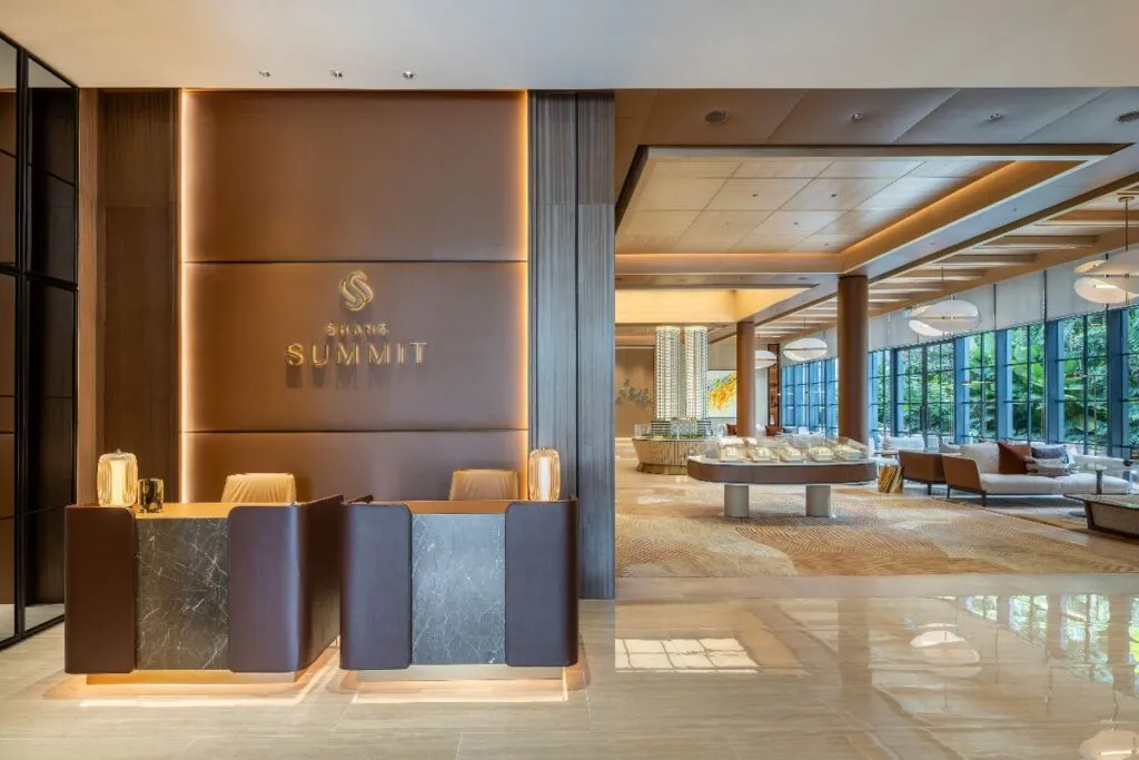 Shang Summit reception and showroom with warm lighting, model displays, lounge seating, and garden views