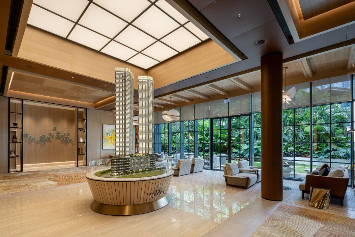 Shang Summit showroom with tower scale model, lounge seating, indoor greenery, and warm modern interiors