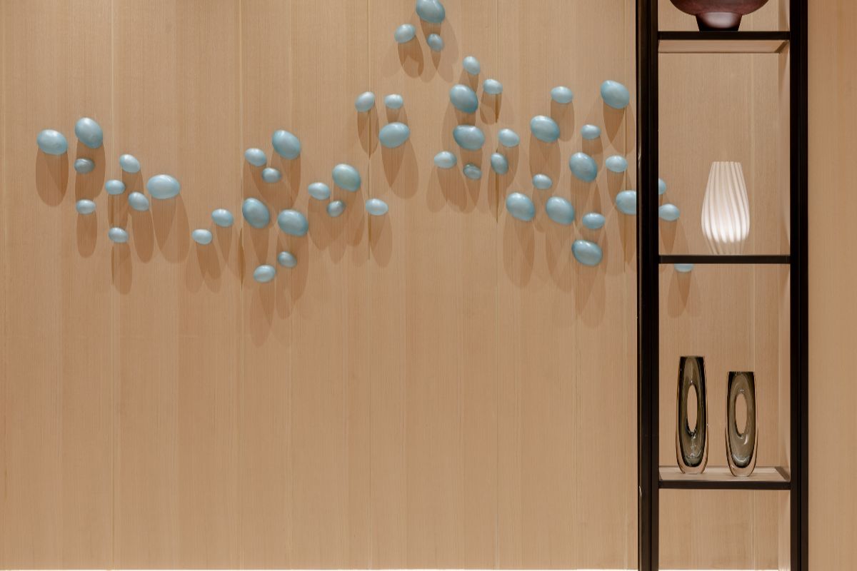 Close-up of handcrafted blue wall accents on a wood-paneled interior with decorative shelving and soft lighting